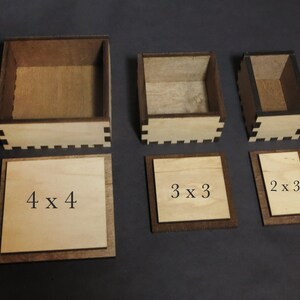 May include: Four wooden boxes with lids, each with a different size. The boxes are labeled with their dimensions: 4 x 4, 3 x 3, and 2 x 3.