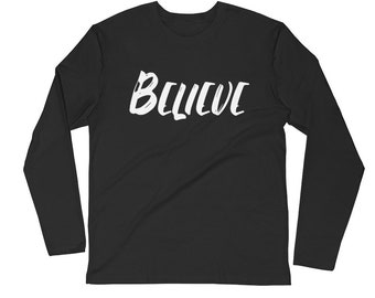 Könnte beinhalten: Schwarzes Langarmshirt mit dem Wort "BELIEVE" in Weiß auf der Vorderseite.