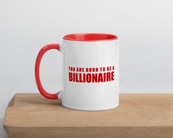 May include: White ceramic mug with a red rim and handle. The mug has the text "You are born to be a BILLIONAIRE" printed in red.