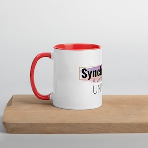 May include: White ceramic mug with a red rim and handle. The mug has a graphic design with the text "Synch A win-win Universe" in black and gold.