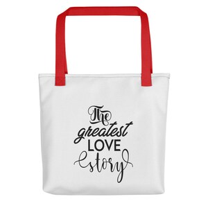 K&ouml;nnte beinhalten: Wei&szlig;e Einkaufstasche mit roten Henkeln. Die Tasche hat schwarzen Text mit der Aufschrift "The greatest love story."