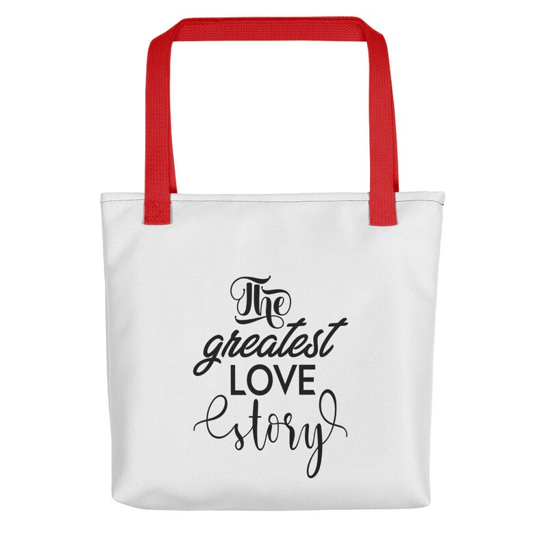 K&ouml;nnte beinhalten: Wei&szlig;e Einkaufstasche mit roten Henkeln. Die Tasche hat schwarzen Text mit der Aufschrift "The greatest love story."