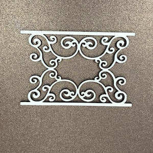 以下が含まれることがあります： スクロールワークパターンが施された白いレーザーカット装飾。デザインは木でできており、繊細で複雑な外観をしています。