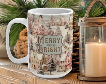 May include: White ceramic coffee mug with a winter scene and the text "Merry and Bright" printed on it. The mug is sitting on a wooden table with a candle and a Christmas tree in the background.