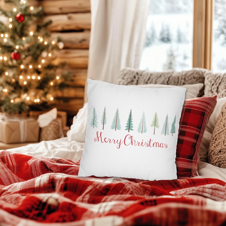 May include: White throw pillow with a row of green Christmas trees and the text "Merry Christmas" in red.