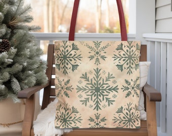 May include: A beige canvas tote bag with red handles and a green snowflake pattern. The bag is sitting on a wooden chair.