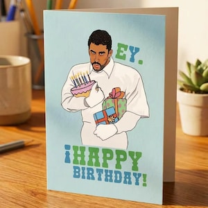 Könnte beinhalten: Geburtstagskarte mit hellblauem Hintergrund. Die Illustration zeigt eine Person, die einen Kuchen mit brennenden Kerzen und verpackten Geschenken hält. Der Text auf der Karte lautet "HEY. ¡HAPPY BIRTHDAY!" in Grün und Blau.