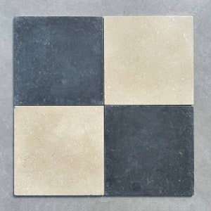 May include: A checkerboard pattern of four square tiles. Two tiles are a light beige colour and two tiles are a dark grey colour.