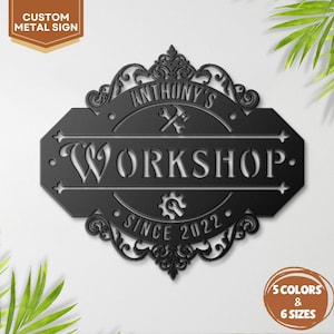 May include: Black metal workshop sign with the text "Anthony's Workshop" and "Since 2022." The sign has decorative scrollwork and a circular design with a wrench and hammer. The sign is available in 5 colors and 6 sizes.