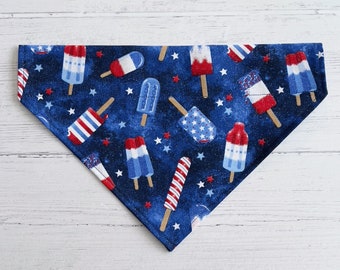 May include: A blue bandana with a white and red stars and ice cream pattern. The ice cream is red, white, and blue.