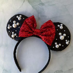 May include: Black mouse ears headband with a red bow and white pearl embellishments.