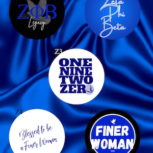 May include: Five circular designs featuring Zeta Phi Beta themes. Z1 is black with a blue dove and ZPB Legacy text. Z2 is blue with white script text. Z3 is white with blue block text reading ONE NINE TWO ZER. Z4 is white with blue script text. Z5 is blue with white text.