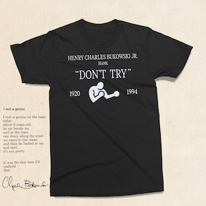Puede incluir: Camiseta negra con texto blanco que dice "HENRY CHARLES BUKOWSKI JR. HANK "DON'T TRY" 1920 1994". Una silueta blanca de una persona levantando pesas se encuentra entre los años.