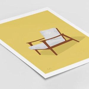 May include: An illustration of a mid-century modern chair. The chair has a brown wooden frame and white cushions, set against a yellow background. The artwork is printed on a white paper.