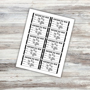 May include: Eight white raffle tickets with black borders and the text "ENTER TO WIN" printed in black. Each ticket has a paw print graphic and lines for name, phone, and email.
