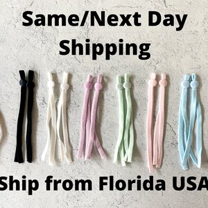 May include: Assortment of 10 pairs of elastic mask strap extenders in various colors, including pink, black, white, lavender, light green, light pink, light blue, and gray.  The extenders are made of soft, stretchy fabric and have adjustable plastic sliders.  "Same/Next Day Shipping" and "Ship from Florida USA" are written in black text at the top and bottom of the image.