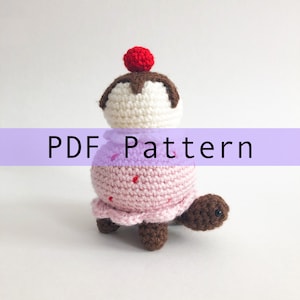 May include: Crochet pattern for a pink and white ice cream cone turtle amigurumi. The pattern is available as a PDF download.
