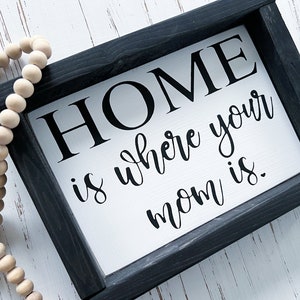 May include: Black framed sign with white background and the text "HOME is where your mom is."