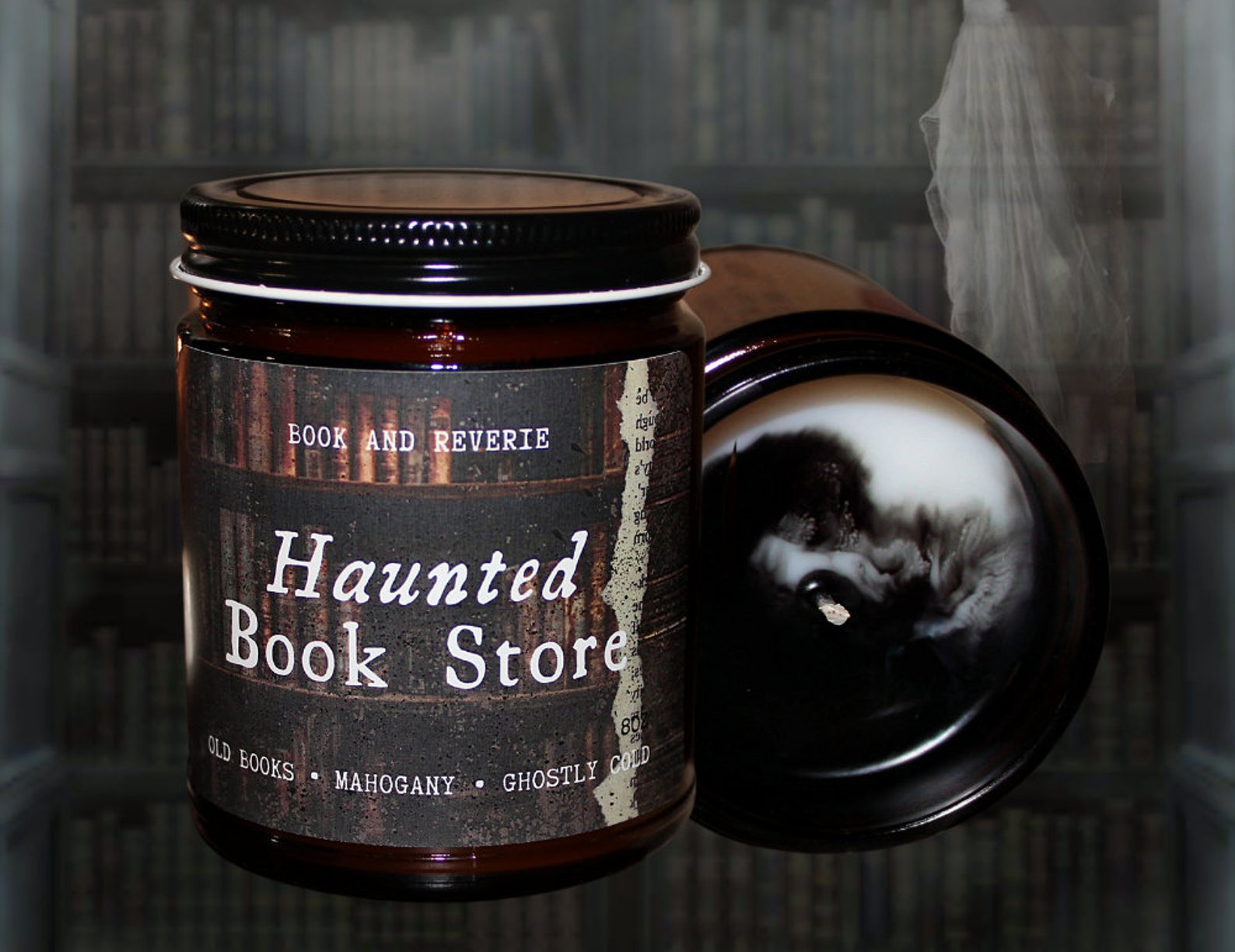 A glass jar candle labeled 'Haunted Book Store' in white script across the front. Another candle, on it's side next to the labeled candle displays the top of the multicolored wax, swirling in black and white.