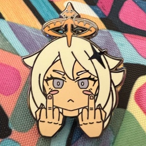 May include: A white and gold enamel pin featuring a cartoon character with blonde hair, a halo, and a serious expression. The character is giving the middle finger with both hands.