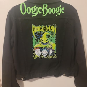 May include: Black denim jacket with a green and yellow graphic of Oogie Boogie from The Nightmare Before Christmas. The text "Oogie Boogie" is written in green on the back of the jacket.