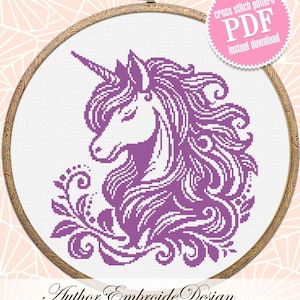 Puede incluir: Patrón de punto de cruz de unicornio morado en un aro de bordado de madera. El patrón presenta un diseño detallado de la cabeza de un unicornio con una melena fluida y un diseño floral. El texto "cross stitch pattern PDF instant download" está en un círculo rosa.