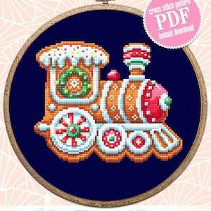 Puede incluir: Un patrón de punto de cruz en PDF para un tren de jengibre con decoraciones de caramelo rojo y verde sobre un fondo azul oscuro. El patrón está disponible para descarga instantánea.