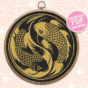May include: A black and gold cross stitch pattern of two koi fish swimming in a yin yang symbol. The pattern is framed in a wooden hoop.