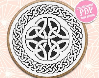 May include: Black and white Celtic knot cross stitch pattern in a wooden embroidery hoop. The pattern is a circle with a four-leaf clover design in the center. The pattern is surrounded by a border of Celtic knots. The pattern is available as a PDF download.