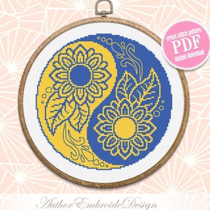 Könnte beinhalten: Ein Kreuzstichmuster eines Yin-Yang-Symbols mit Sonnenblumen in Gelb und Blau. Das Muster befindet sich in einem hölzernen Stickrahmen und ist als PDF-Download verfügbar.