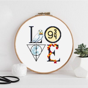 May include: Cross stitch pattern of the word "LOVE" with Harry Potter themed icons. The "L" is a white owl holding a letter, the "O" is the platform 9 3/4 sign, the "V" is the Deathly Hallows symbol, and the "E" is a red and gold scarf.