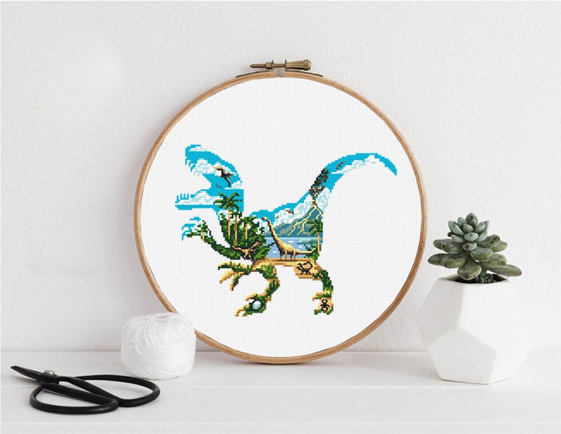 May include: A cross-stitch pattern of a blue dinosaur silhouette with a tropical island scene inside. The dinosaur is facing left and has a long tail. The island scene includes palm trees, a mountain, and a body of water.