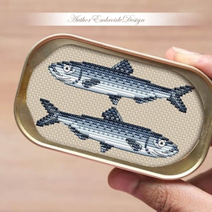 May include: Two silver fish in a tin can, a cross-stitch design.