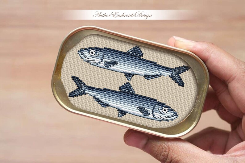 May include: Two silver fish in a tin can, a cross-stitch design.