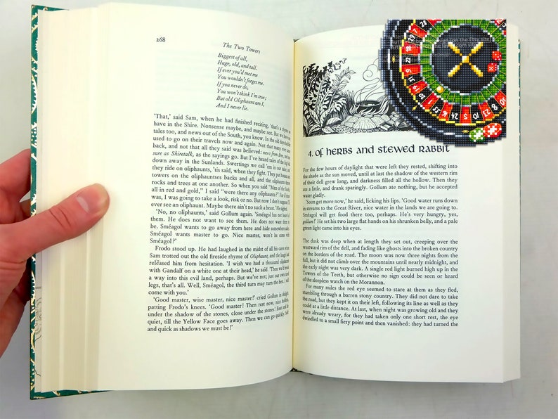 Op de afbeelding: Een open boek met een zwart-witte illustratie van een bos sc&egrave;ne op de linkerpagina en een zwart en groen roulettewiel op de rechterpagina. De tekst op de linkerpagina luidt "The Two Towers" en "Bigger of all, Huge, old and tall, If ever you meet me You would never forget me. You were old when I was young, But you weren't as strong. You couldn't catch me, And I never met..."