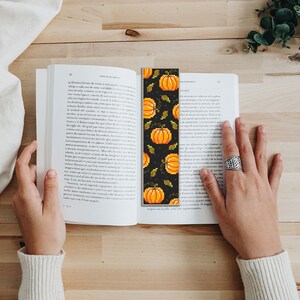 May include: A black and orange beaded bookmark with a pattern of pumpkins and leaves. The bookmark is about 10 inches long.