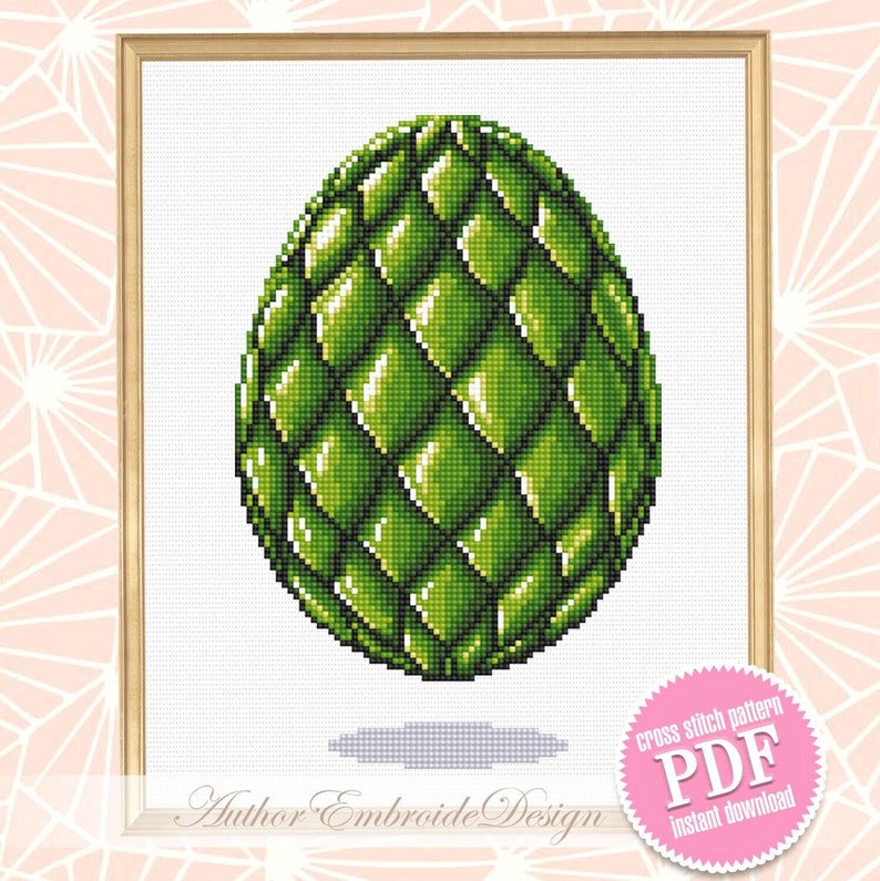 May include: A framed cross-stitch pattern featuring a green, textured egg design. The egg has a scale-like pattern and is set against a white background. The frame is a light wood color. The image includes the text "Author Embroide Design" and "Cross stitch pattern PDF instant download".