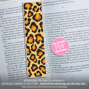 May include: A cross stitch pattern for a bookmark featuring a leopard print design in shades of orange, yellow, and black. The pattern is on a beige background. The text "cross stitch pattern PDF instant download" is on a pink circle.