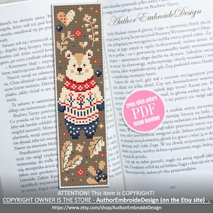 May include: A cross stitch pattern for a bookmark featuring a brown bear wearing a red, white, and blue sweater. The bear is surrounded by leaves and flowers. The pattern is available as a PDF download. The text "Author Embroide Design" is visible in the upper right corner of the image.