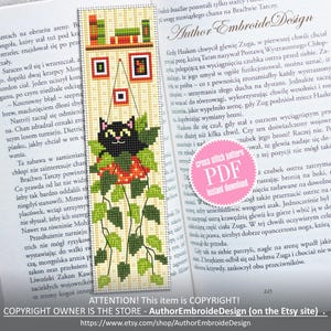 May include: A cross-stitch bookmark with a black cat, green leaves, and red berries. The bookmark has a beige background with a shelf and framed pictures at the top. The text "Author EmbroideDesign" is visible.