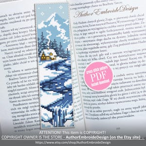 May include: Cross-stitch bookmark depicting a winter scene with a snow-covered mountain, trees, and a small cabin. The bookmark is blue and white, with a cross-stitch design. The text "Author Embroide Design" is visible.