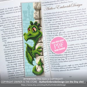 Pode incluir: Marcador de livros artesanal com um design de dragão verde pixelizado. O dragão está posicionado ao lado de uma parede de pedra, com um fundo azul claro. O marcador de livros é exibido em um livro aberto.