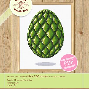 May include: A framed cross-stitch pattern featuring a green, textured egg design. The pattern is 4.56 x 7.00 inches and available for instant download. The design includes 8 colors and is on 16 count White Aida fabric.