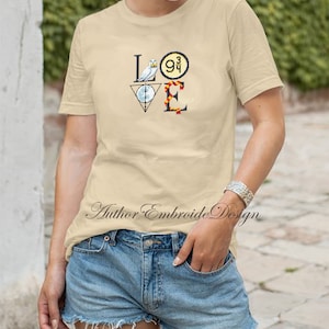 May include: A beige t-shirt with a graphic design of the word "LOVE" made up of Harry Potter themed icons. The "L" is a white owl, the "O" is a golden snitch, the "V" is a triangle with a circle inside, and the "E" is a red and gold scarf.