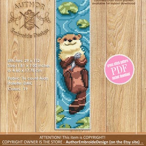 May include: A cross-stitch pattern featuring an otter holding a fish, set against a blue water background with lily pads. The design measures 1.81 x 7.00 inches. The text says "counted cross stitch pattern available for instant download".