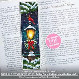 May include: Cross-stitch bookmark depicting a winter scene with a red cardinal on a lamppost. The design includes snow, a red bow, and the text "Author Embroide Design" on a book page. A PDF download is available.