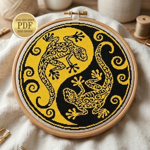 May include: A cross-stitch pattern featuring a Yin and Yang design with two stylized lizards in black and yellow. The design is set in a wooden embroidery hoop. The text "Cross stitch pattern PDF instant download" is in the upper left corner.