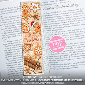 May include: A cross stitch bookmark with a beige background featuring a gingerbread house, cinnamon sticks, and a star anise. The bookmark has the text "Merry Christmas" in red and white lettering.
