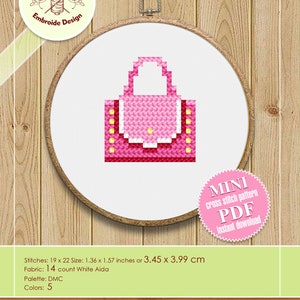 May include: A pink and white cross stitch pattern of a small handbag with yellow accents. The pattern is available as a digital download in PDF format. The pattern is 1.36 inches by 1.57 inches or 3.45 cm by 3.99 cm and uses 14 count white Aida fabric.