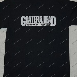 May include: Black t-shirt with a white graphic print of "Grateful Dead" and the text "Stronger Than All".